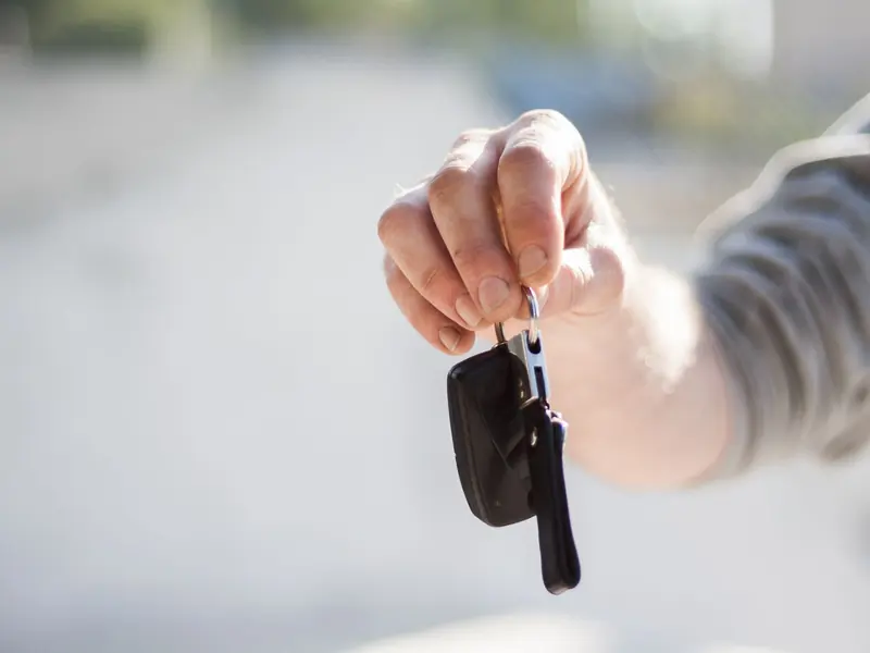 Hand holding out car keys