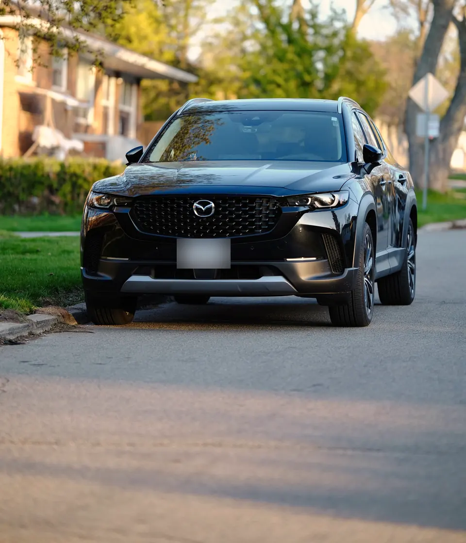 Black Mazda SUV parked on a residential street